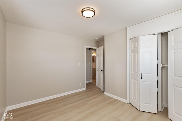 unfurnished bedroom with a closet and light wood-type flooring