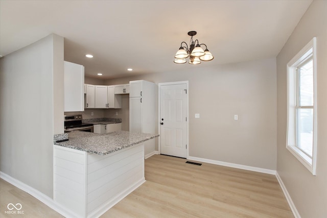 kitchen with white cabinetry, electric range, plenty of natural light, decorative light fixtures, and kitchen peninsula