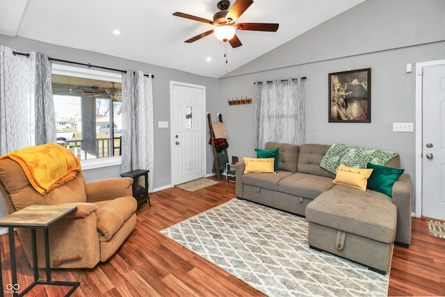 living room with hardwood / wood-style flooring, vaulted ceiling, and ceiling fan