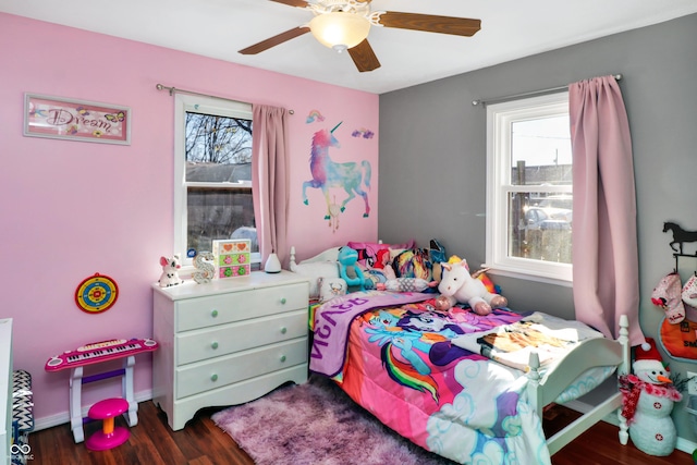 bedroom featuring multiple windows, dark hardwood / wood-style flooring, and ceiling fan