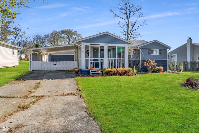 view of front of house with a front yard, a sunroom, and a carport