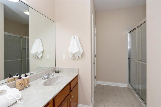 bathroom featuring a shower with door, vanity, and tile patterned floors