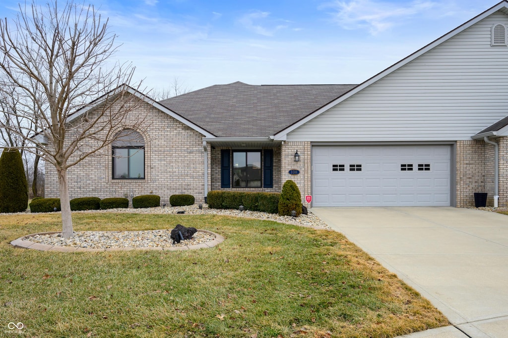 ranch-style home featuring a garage and a front lawn