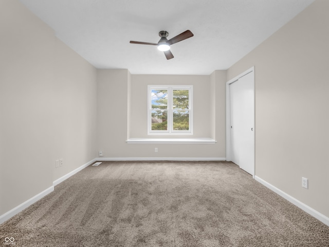 spare room featuring carpet flooring and ceiling fan