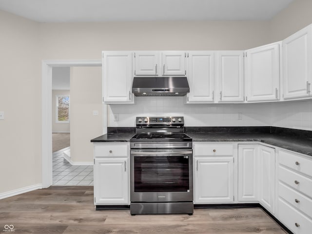 kitchen with white cabinetry, decorative backsplash, light wood-type flooring, and electric stove