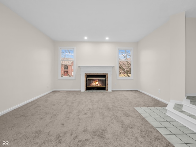 unfurnished living room featuring a fireplace and light carpet