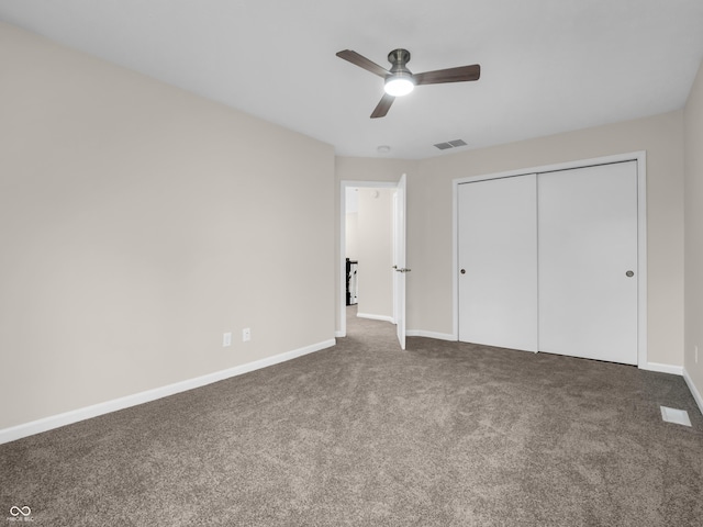 unfurnished bedroom featuring ceiling fan, dark carpet, and a closet