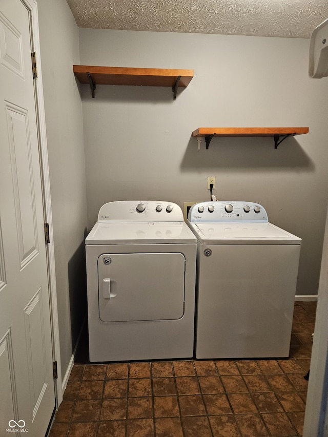 laundry area with separate washer and dryer and a textured ceiling