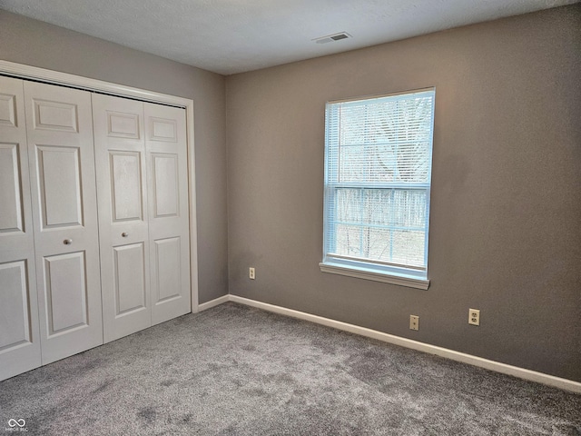 unfurnished bedroom with carpet and a closet