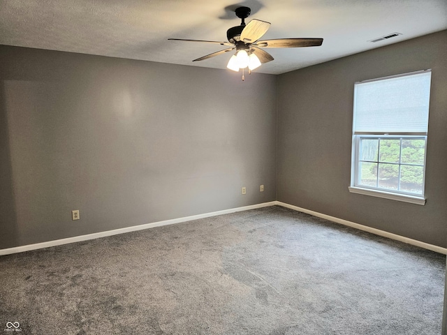 carpeted empty room with a textured ceiling and ceiling fan