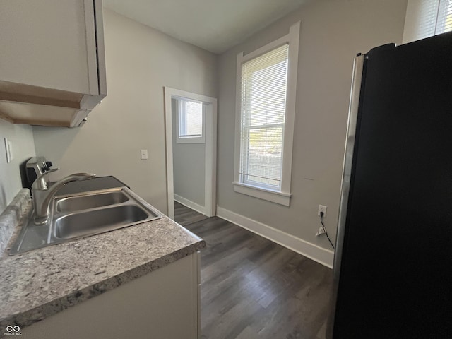 kitchen featuring stainless steel refrigerator, dark hardwood / wood-style flooring, and sink