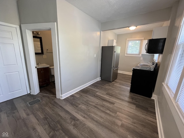 kitchen featuring white cabinets, sink, stainless steel fridge, and dark hardwood / wood-style flooring