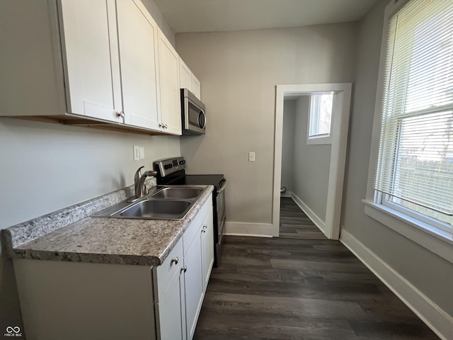 kitchen featuring white cabinetry, appliances with stainless steel finishes, sink, and dark wood-type flooring