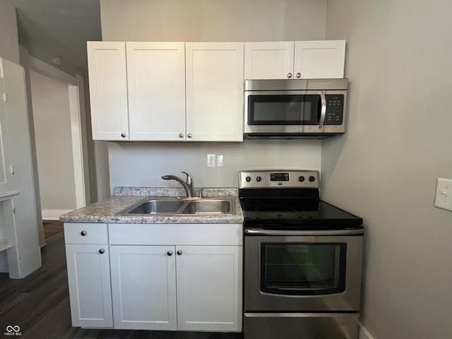 kitchen featuring white cabinetry, appliances with stainless steel finishes, dark hardwood / wood-style flooring, and sink