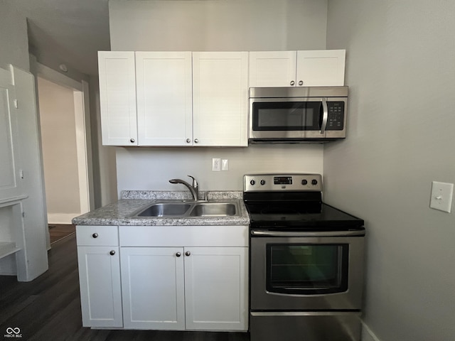 kitchen featuring stainless steel appliances, sink, white cabinets, and dark hardwood / wood-style floors