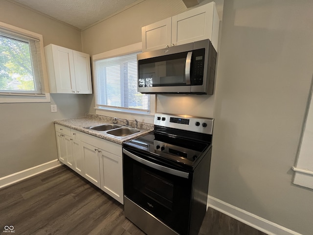 kitchen featuring appliances with stainless steel finishes, sink, white cabinets, and dark hardwood / wood-style floors