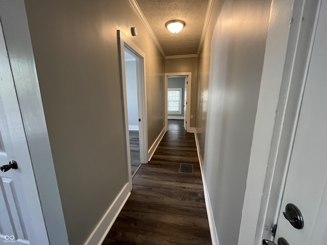 hall featuring ornamental molding, dark hardwood / wood-style floors, and a textured ceiling