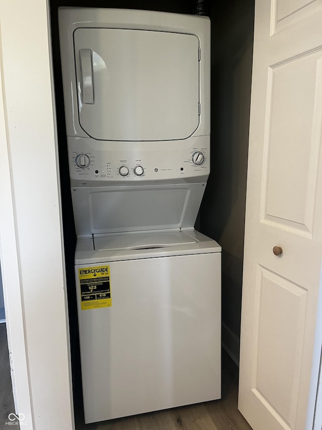 washroom featuring stacked washer / drying machine and dark hardwood / wood-style floors