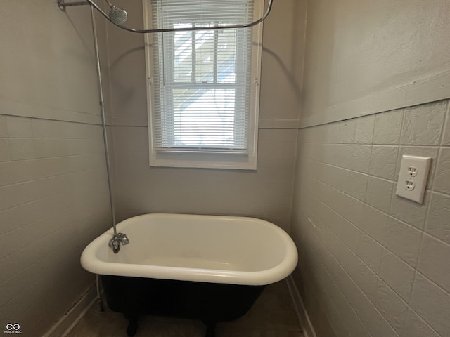 bathroom with tile walls and a tub