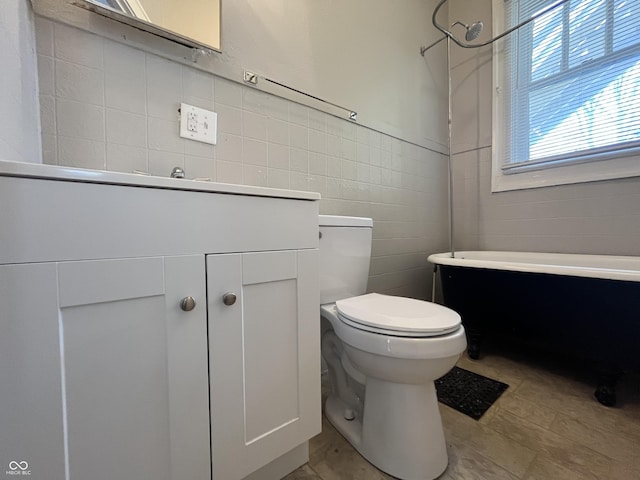 bathroom with vanity, tile walls, and toilet