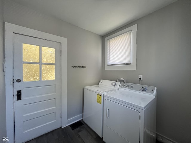 laundry room featuring dark wood-type flooring, a wealth of natural light, and independent washer and dryer