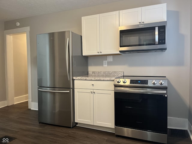 kitchen featuring appliances with stainless steel finishes, white cabinets, and dark hardwood / wood-style flooring