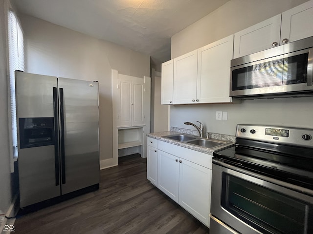 kitchen featuring appliances with stainless steel finishes, sink, dark wood-type flooring, and white cabinets