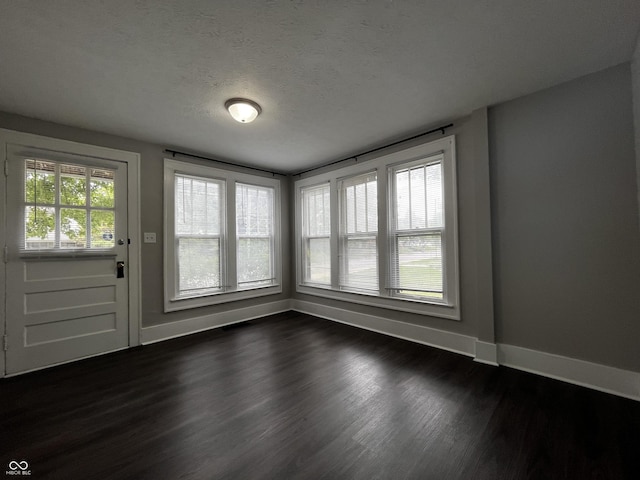 interior space with dark wood-type flooring and a textured ceiling