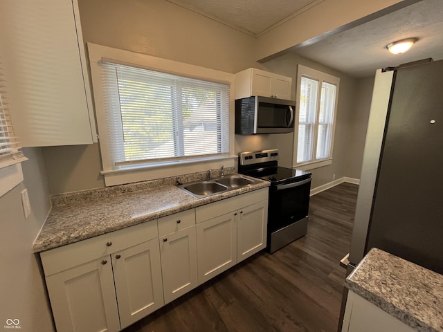 kitchen featuring sink, appliances with stainless steel finishes, a textured ceiling, white cabinets, and dark hardwood / wood-style flooring