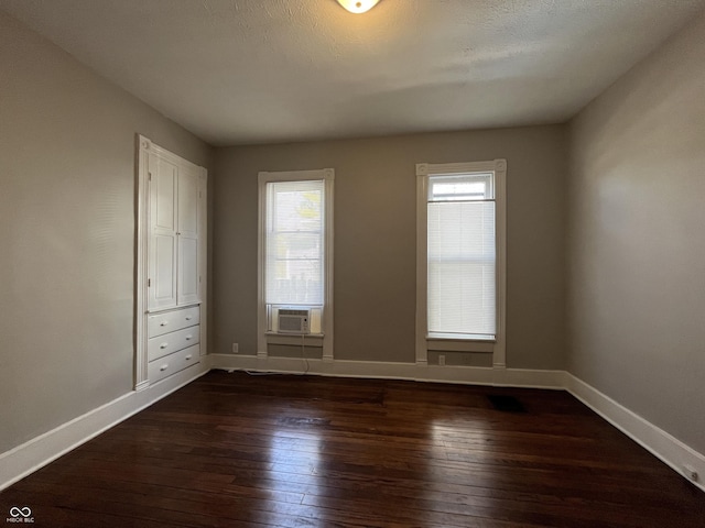 unfurnished room with cooling unit and dark hardwood / wood-style flooring