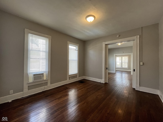 empty room featuring cooling unit and dark hardwood / wood-style flooring