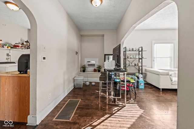 corridor with dark hardwood / wood-style flooring and a textured ceiling