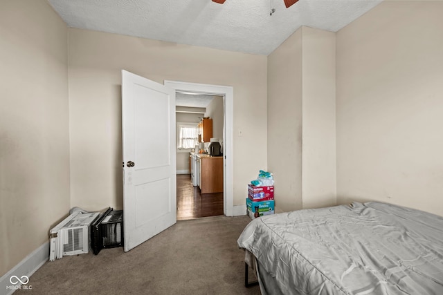 bedroom with ceiling fan, carpet floors, and a textured ceiling