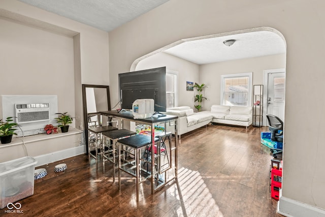 dining area with dark wood-type flooring and a textured ceiling