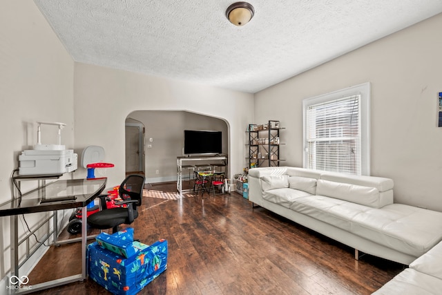 living room with dark wood-type flooring and a textured ceiling