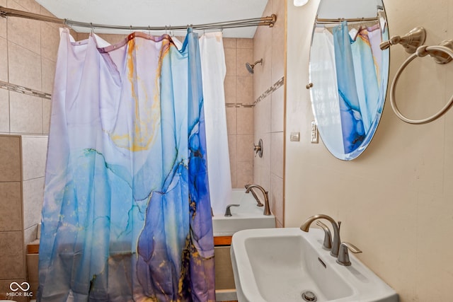 bathroom with shower / bath combination with curtain and sink