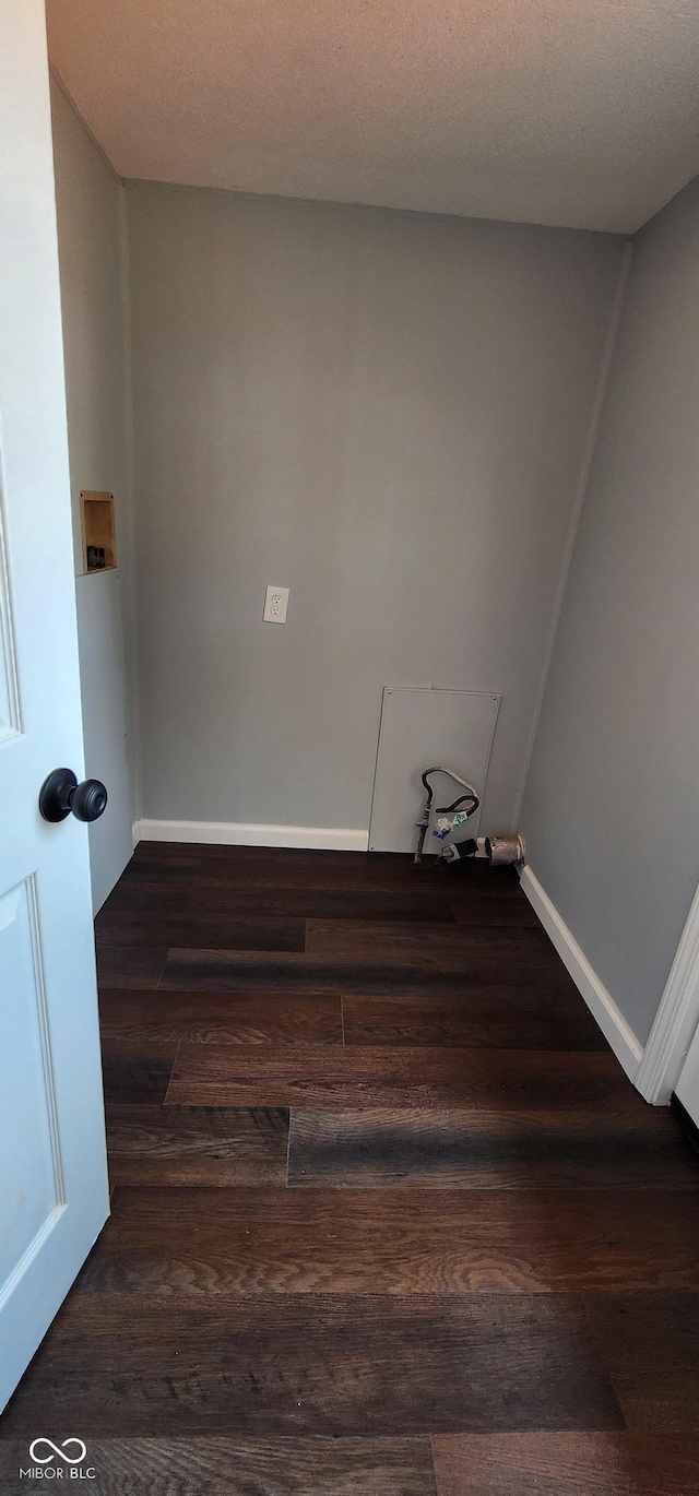 laundry room featuring dark hardwood / wood-style floors and a textured ceiling