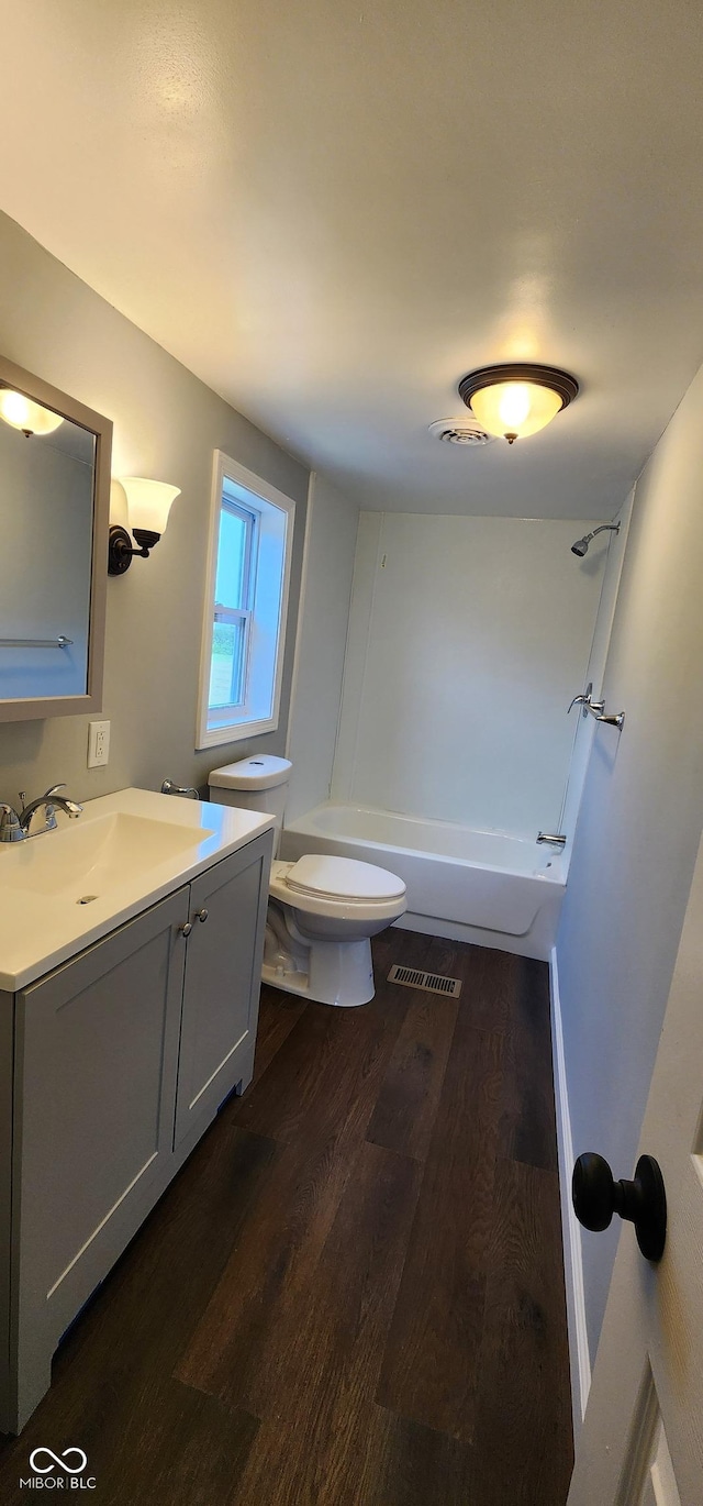 full bathroom with shower / tub combination, wood-type flooring, vanity, and toilet