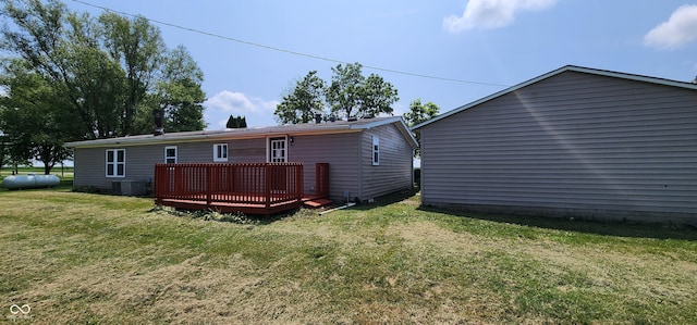 rear view of property featuring a lawn and a deck