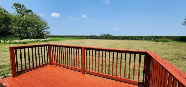 deck with a rural view and a yard