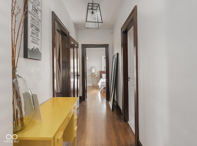 hall with baseboards and dark wood-style flooring