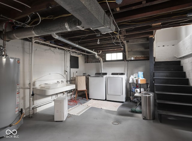 basement featuring water heater, independent washer and dryer, stairs, and a sink