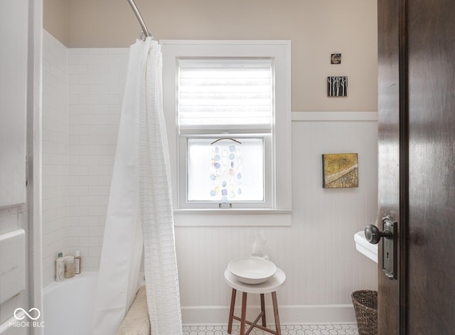 full bathroom with shower / tub combo and baseboards