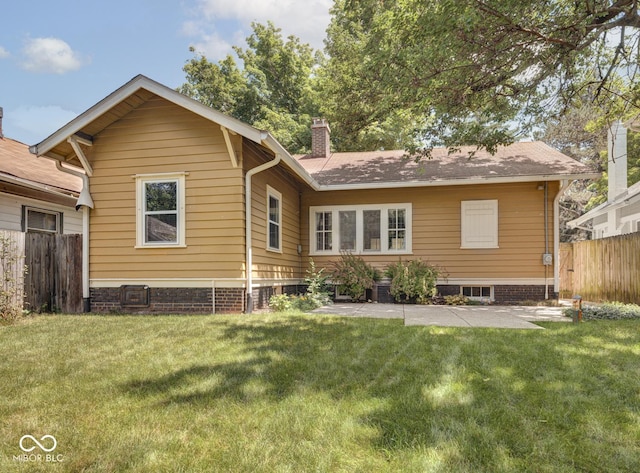 rear view of property with fence, a lawn, central AC, and a chimney