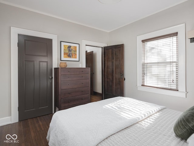 bedroom featuring a closet, dark wood-style floors, and crown molding