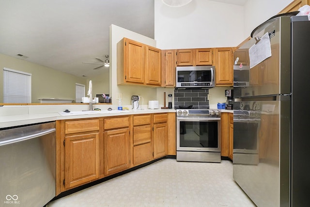 kitchen with appliances with stainless steel finishes, sink, and ceiling fan