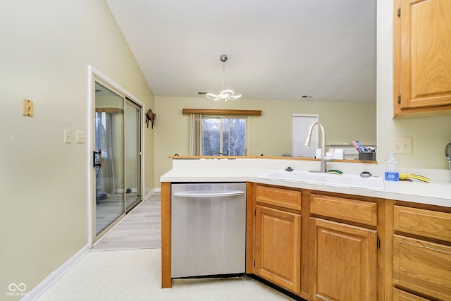 kitchen featuring sink, decorative light fixtures, vaulted ceiling, stainless steel dishwasher, and kitchen peninsula