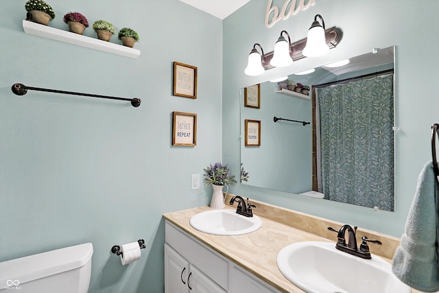 bathroom featuring vanity, curtained shower, and toilet