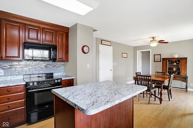 kitchen featuring a kitchen island, black appliances, backsplash, ceiling fan, and light hardwood / wood-style floors