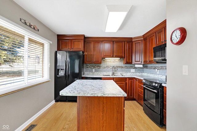 kitchen with tasteful backsplash, sink, black appliances, and a kitchen island